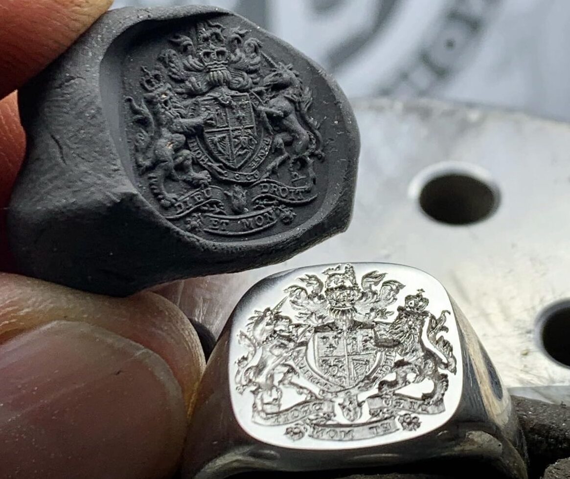 A coat of arms hand engraved into a signet ring, with the crisp wax impression it leaves